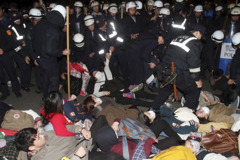 Taiwanese student demonstrators are removed by police after storming the government cabinet offices in Taipei. Photo: AP