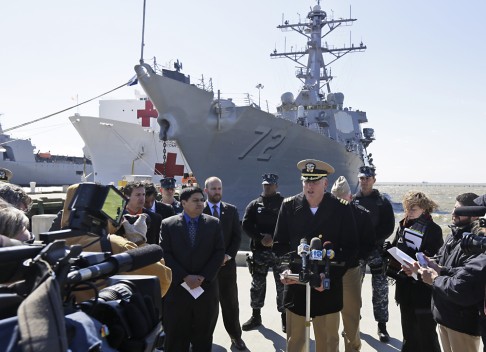 Commanding officer of the USS Manham, Commander Zoah Scheneman at podium, addresses the media during a press conference in front of the ship at Naval Station Norfolk on March, 2014. Photo: AP