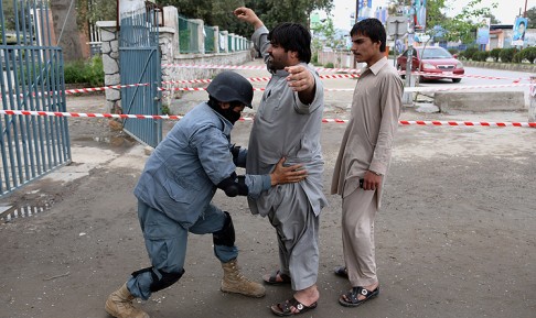 An Afghan policeman checks a voter at a polling station in Jalalabad. Photo: AP