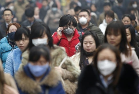 Commuters wearing masks go to work amid a thick haze in the morning in Beijing. Photo: Reuters