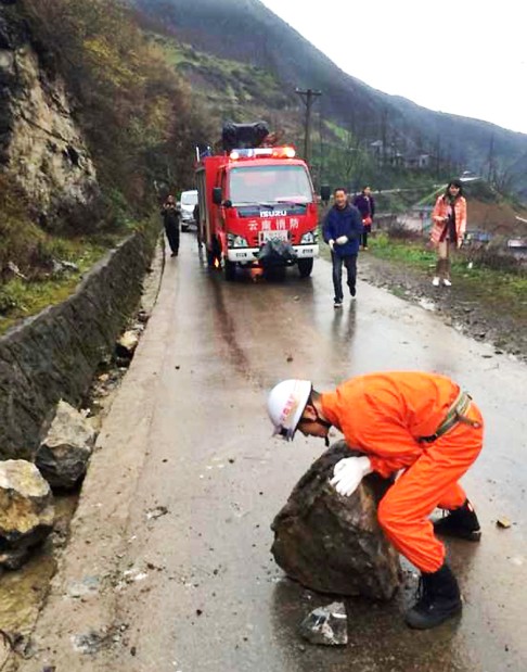 A fireman tries to remove rocks rolling down from mountains in quake-hit Yongshan County. Photo: Xinhua