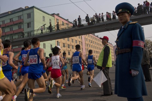 Runners pass under a pedestrian bridge in central Pyongyang during the running of the Mangyongdae Prize International Marathon. Photo: AP 