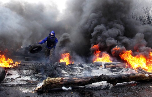 A pro-Russian protester burns tires in prepararation for battle with the Ukrainian special police forces on the outskirts of the eastern Ukrainian city of Slavyansk on April 13, 2014. Photo: AFP