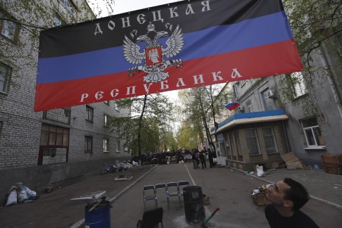 A man looks at a flag of a self-proclaimed Donetsk republic in front of a captured police station in Slavyansk. Photo: AFP