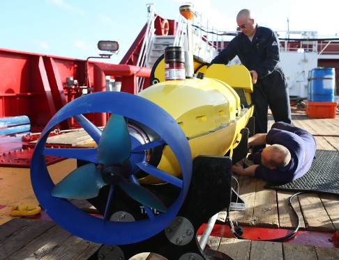 Australian technicians conduct checks on the underwater autonomous vehicle. Photo: Xinhua