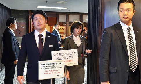 Plainclothes policemen stand guard at the Tokyo sushi restaurant Sukiyabashi Jiro where Obama and Abe are expected to dine. Photo: AFP