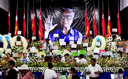 People set flowers in front of the portrait of late Myanmar democracy activist Win Tin at the official memorial ceremony in Yangon, Myanmar on April 22, 2014. Photo: EPA