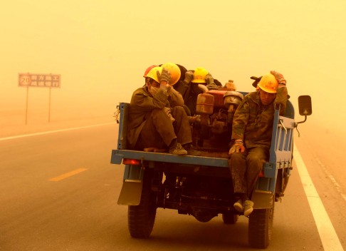 A vehicle carrying building workers in a sandstorm on the outskirt of Guazhou in Jiuquan. Photo: Xinhua
