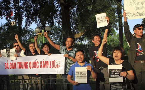 Protesters shout as they hold an anti-China banner which reads, 'down with China' at a park in front of Chinese embassy in Hanoi on Friday. Photo: Reuters