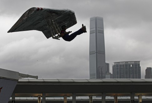 A participant sits in his self-made aircraft flying in front of the International Commerce Centre (ICC) at the Red Bull Flugtag. Photo: AP