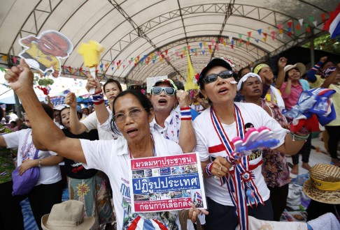 Thai anti-government protesters shout slogans with banner reading 'political reforms before election' during a rally at Government House in Bangkok. Photo: EPA