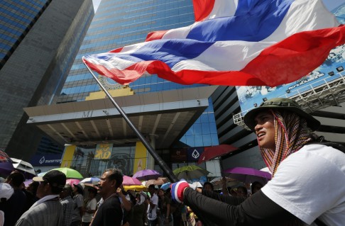 Anti-government protesters waving a giant Thai flag. The government’s enemies deride its legitimacy and are calling for the appointment of a new prime minister. Photo: EPA