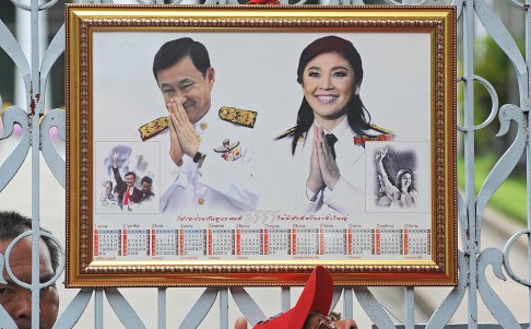 A portrait of Thailand's ousted prime ministers Thaksin and Yingluck Shinawatra displayed by pro-government red shirt activists. Photo: AFP
