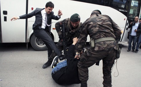 Yusuf Yerkel, an adviser to Erdogan, kicks a protester, reported to be a relative of one of the victims, as he is pinned to the ground by special forces police. Photo: AFP