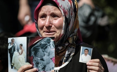 A Turkish woman shows photos of her son, a mine accident victim, in Soma. Photo: AP
