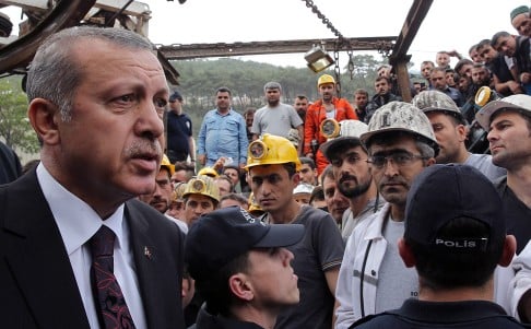 Turkish Prime Minister Recep Tayyip Erdogan is surrounded by security members as he visits the coal mine in Soma. Photo: AP