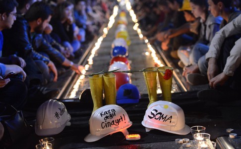People gather to commemorate the Soma mine accident victims and protest the government's labour policy in Istanbul late on Friday. The writing on the miner's helmet reads: "Not accident, but murder". Photo: AP
