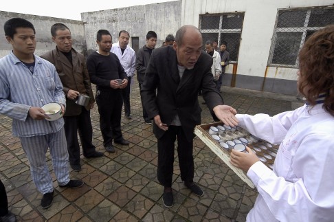 Patients line up to receive medicine from a nurse at a mental hospital in Changzhi, Shanxi province. Photo: Reuters