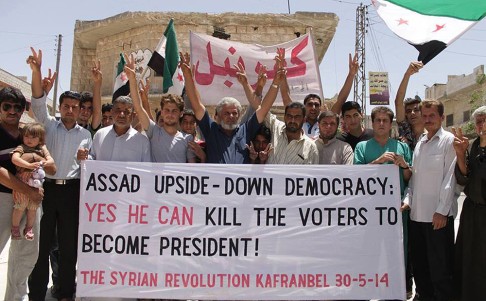 Protestors opposing Syrian President Bashar al-Assad carry a banner during a demonstration at Kafr Nabil town in Idlib province, northern Syria last week. Photo: AP