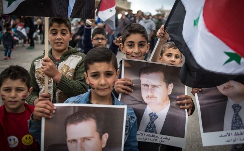 Syrian children hold posters of president and candidate Bashar al-Assad during a rally on Monday. Photo: Xinhua