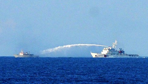 A Chinese Coast Guard ship (right) using a water cannon to attack a Vietnamese Fisheries Surveillance boat near to the site of the Chinese oil rig in early June. Both sides have traded accusations over encounters at sea. Photo: AFP