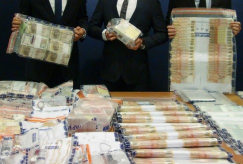 Bundles of cash, luxury watches and computers seized when a cross-border gambling syndicate was smashed last week. Photo: SCMP Pictures