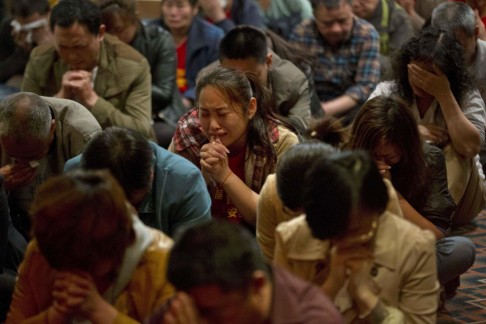 Relatives of passengers on Flight MH370 pray in Beijing. Photo: AP