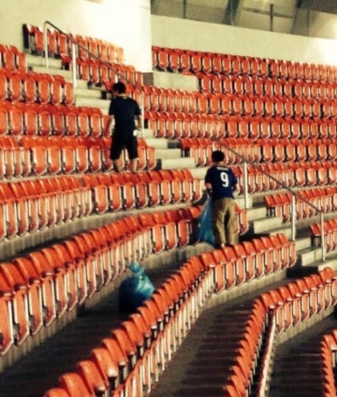 Japanese fans pick up rubbish from the stands