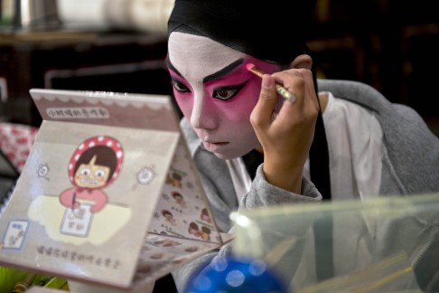 An actress puts on makeup before a performance at the West Kowloon Bamboo Theatre in Hong Kong. Photo: AFP