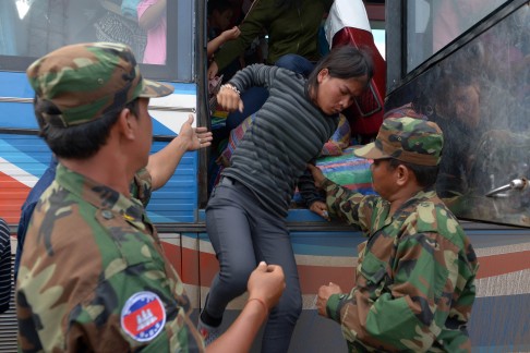 Cambodian soldiers help a migrant worker from a vehicle that crossed Thailand's border. Photo: AFP
