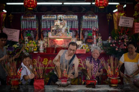 Lighting incense for the Hungry Ghost Festival. Photo: AFP