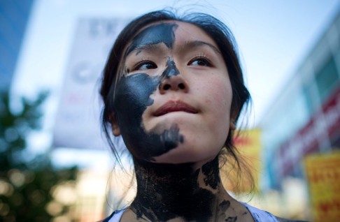 Demonstrator Jacqueline Lee-Tam wears face paint simulating oil at a protest against the pipeline in Vancouver. Photo: AP