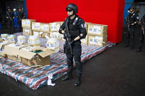 Police officers stand guard next to confiscated drugs on display in Shanghai on Thursday. Photo: Reuters