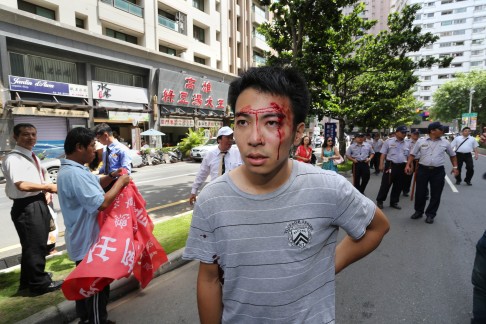 An injured protester walks away after scuffling with police outside the venue where Zhang Zhijun was holding meetings in the southern Taiwanese city of Kaohsiung at the weekend. Photo: AFP