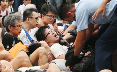 Police attempt to drag away protesters from the sit-in on Chater Road. Photo: Felix Wong