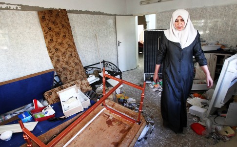 Nadia Abu Eishe, the mother of Amer Abu Eishe, a Palestinian member of the Islamist Hamas in Hebron named by Israel as one of the two prime suspects in the murder of three kidnapped Israeli teenagers, inspects her house after Israeli forces searched it. Photo: AFP
