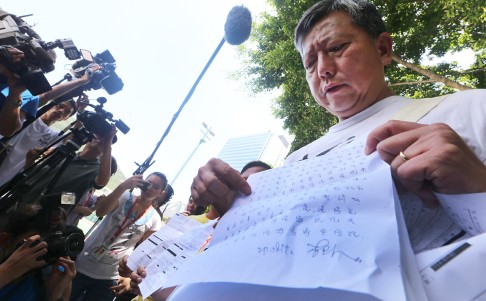Lawmaker Lee Cheuk-yan of the Labour Party, arrested during the sit-in, holds up his written warning. Photo: David Wong