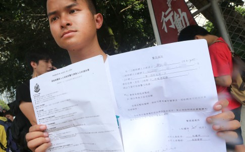 District councillor Eric Lam Lap-chi, who accused the police of using excessive force, holds up the written warning he received from police. Photo: David Wong