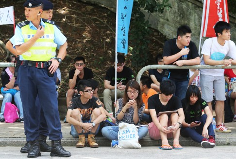 People wait outside the Police College for word on those being held inside. Photo: David Wong