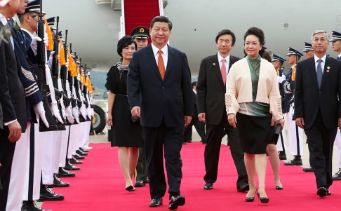 Chinese President Xi Jinping (front left) and his wife Peng Liyuan inspect an honor guard upon their arrival in Seoul. Photo: Xinhua