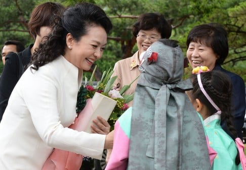 Chinese first lady Peng Liyuan (left) is greeted by South Korean children upon her arrival at Changdeok Palace in Seoul. Photo: AP