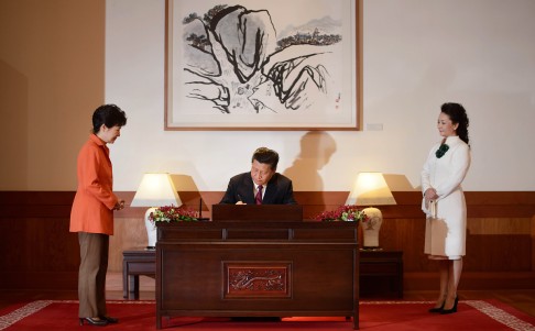 Xi signs a guest book, as Park and wife Peng Liyuan watch. Photo: AP