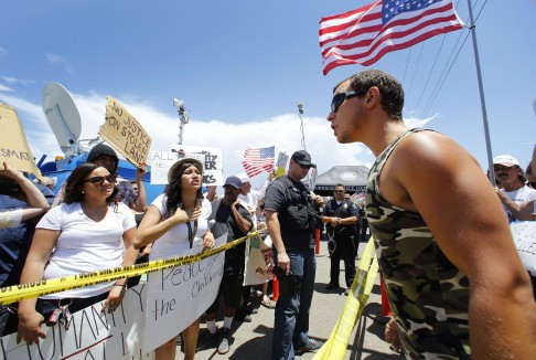 Protesters from both sides of the debate argue across police lines. Photo: AP