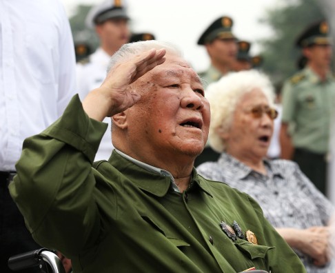 A war veteran sings the national anthem at the ceremony. Photo: Xinhua