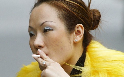 A fashionable girl smokes on a chilly afternoon in Shanghai. Photo: AFP