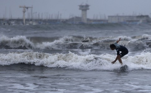 A surfer enjoys the waves as tropical storm Neoguri approaches in Kamakura. Photo: Reuters
