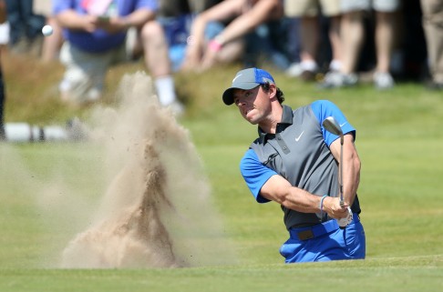 Rory McIlroy blasts out of a bunker on the 16th hole, leading to another birdie. Photo: AP