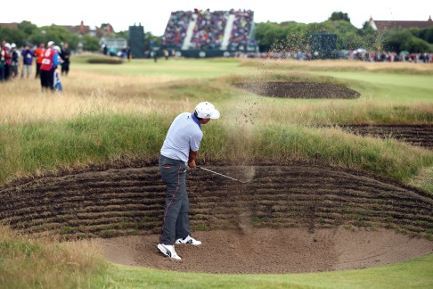 American Rickie Fowler plays out of a bunker on the 17th hole during his third round 68 on day three of the 2014 British Open. Photo: AFP 