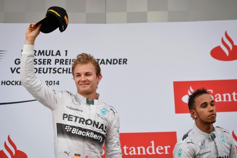 Nico Rosberg celebrates his victory at the German Grand Prix, while Lewis Hamilton salvaged third after starting from 20th. Photo: EPA