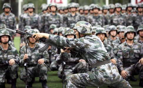 A training officer demonstrates the use of a rifle with a knife extension as cadets watch at the People's Liberation Army Academy of Armored Forces Engineering in Beijing. Photo: EPA